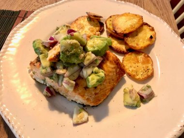 Avokado, Kırmızı Soğan ve Deniz Ürünleri Tabağında Fırında Yuvarlak Patates Dilimleri ile Somon Balık Fileto. 