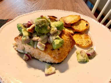 Avokado, Kırmızı Soğan ve Deniz Ürünleri Tabağında Fırında Yuvarlak Patates Dilimleri ile Somon Balık Fileto. 