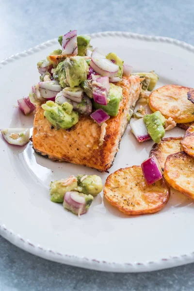 Salmon Fish Fillet with Avocado, Red Onions and Baked Round Potato Slices in Seafood Plate.