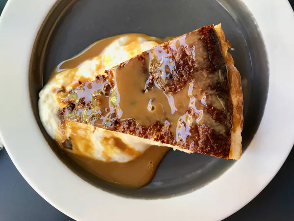 Rebanada de pastel de queso con salsa Dulce De Leche servida en plato / mermelada de leche para postre orgánico . — Foto de Stock