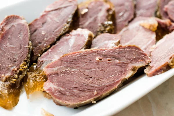 Carne ahumada rebanadas de mejilla de ternera en tablero de madera. Listo para comer . —  Fotos de Stock