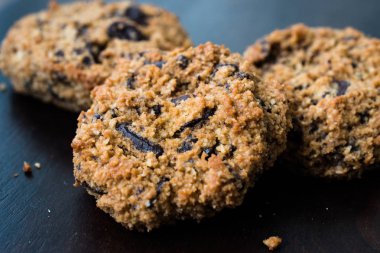 Koyu Ahşap Tahta üzerine Hindistan cevizi ve badem unu ile yapılan Paleo Çikolatalı Kurabiye.