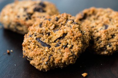 Koyu Ahşap Tahta üzerine Hindistan cevizi ve badem unu ile yapılan Paleo Çikolatalı Kurabiye.