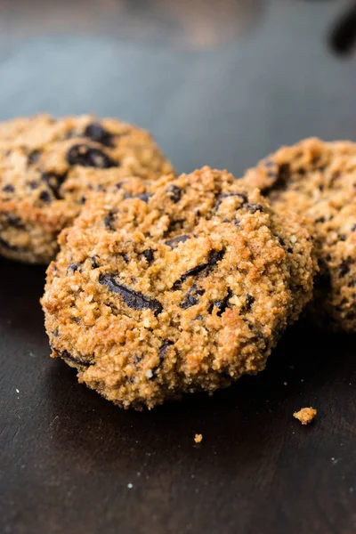 Paleo Chocolate Chip koekjes gemaakt met kokos en amandelmeel op donkere houten plank. — Stockfoto