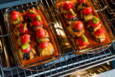 Fırında Tepside Patlıcana Sarılmış Köfte li ve Çeri Domatesli Türk İslim Köfte Kebabı. 