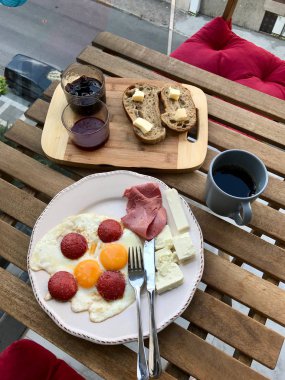 Kızarmış Yumurtalı Türk Kahvaltısı Sucuk, Eritilmiş Peynir, Tereyağlı Ekmek ve Reçel / Marmelat Taze Filtre Kahve ile servis edilir. 