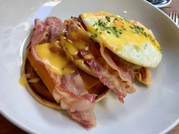 Panquecas salgadas com molho holandês, queijo Cheddar derretido, ovos e bacon crocante para o café da manhã — Fotografia de Stock