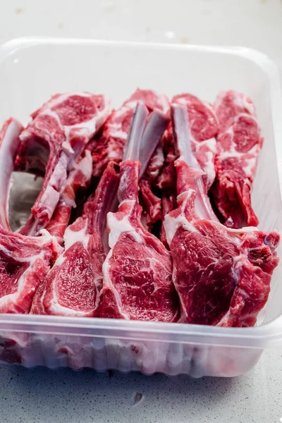 Raw Bloody Lamb Chops Meat in Plastic Package / Box or Container
