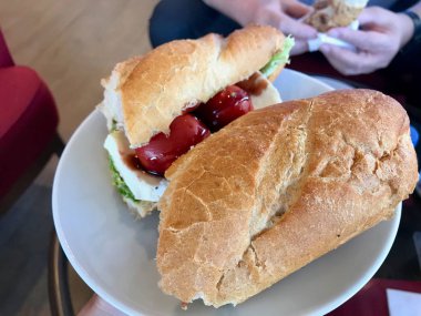 Baget Ekmeğinde Vişneli Domatesli Ve Marul Yapraklarıile Soğuk Mozzarella Peynirli Sandviç.