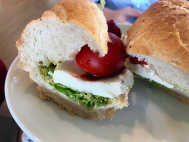 Baget Ekmeğinde Vişneli Domatesli Ve Marul Yapraklarıile Soğuk Mozzarella Peynirli Sandviç.