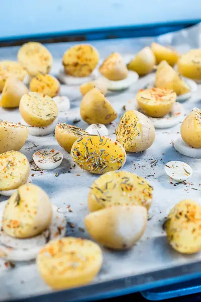 Rauwe pittige baby aardappelen op bakpapier klaar om te bakken. — Stockfoto