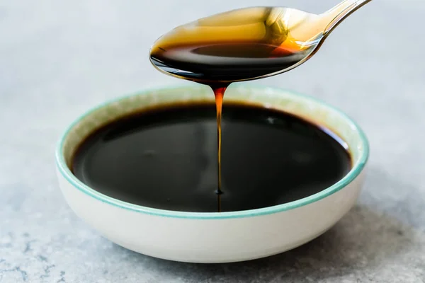 Organic Black Cane Sugar Molasses Dripping from Spoon — Stock Photo, Image