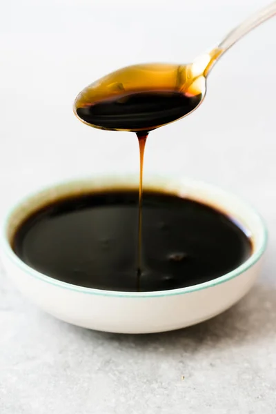 Szerves fekete nád cukor melasz csöpögő a Spoon — Stock Fotó