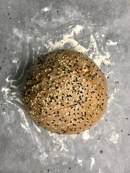 小麦粉のベーキングペーパーにブラッククミン種子を入れたカラキルチク小麦生パン. — ストック写真