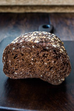 Koyu Ahşap Tahtada Yulaf ve Keten Tohumu ile Malt Ekmek Dilimleri. 