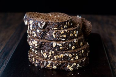 Koyu Ahşap Tahtada Yulaf ve Keten Tohumu ile Malt Ekmek Dilimleri. 