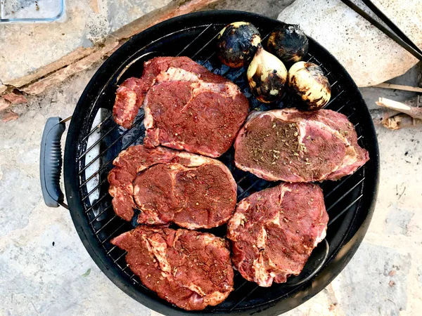 Готовить сырое мясо на барбекю с луком . — стоковое фото