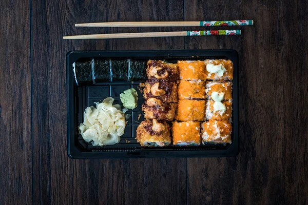 Set de sushi en caja / paquete de contenedor de plástico. California Roll, New York Roll, Boom Roll, Jengibre, Wasabi y salsa de soja . — Foto de Stock