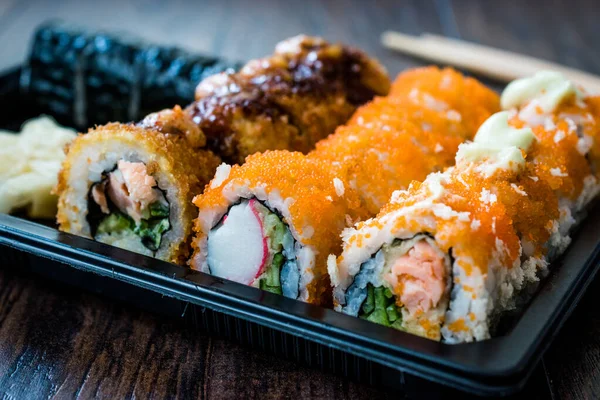 Set de sushi en caja / paquete de contenedor de plástico. California Roll, New York Roll, Boom Roll, Jengibre, Wasabi y salsa de soja . — Foto de Stock