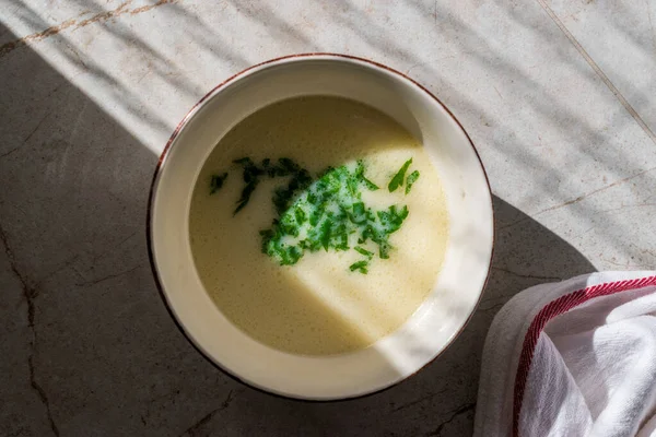 Zelfgemaakte kippenbouillon soep met peterselie in natuurlijk daglicht. — Stockfoto