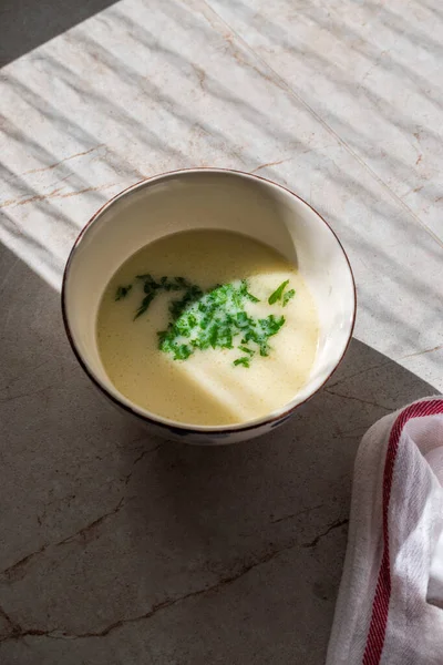 Zelfgemaakte kippenbouillon soep met peterselie in natuurlijk daglicht. — Stockfoto