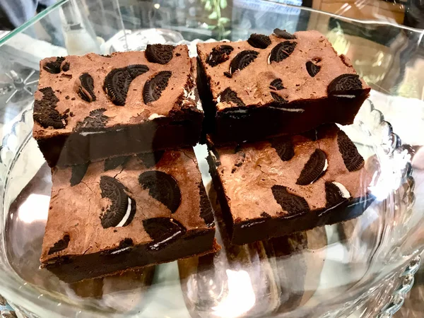 Brownie con galletas de chocolate en bandeja de vidrio en el escaparate de la cafetería . — Foto de Stock