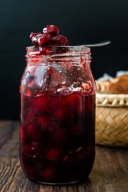 Kavanozda yaban mersini reçeli ile yaban mersini marmelatı Wicker Bowl 'da ekmek dilimleri ile servis edilir..
