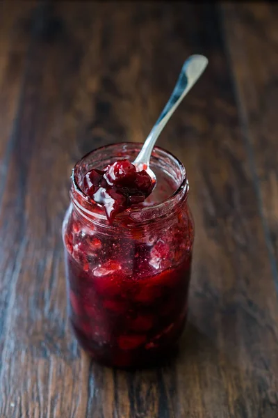 Confiture de canneberges en pot avec cuillère / confiture de canneberges servie avec tranches de pain pour le petit déjeuner . — Photo