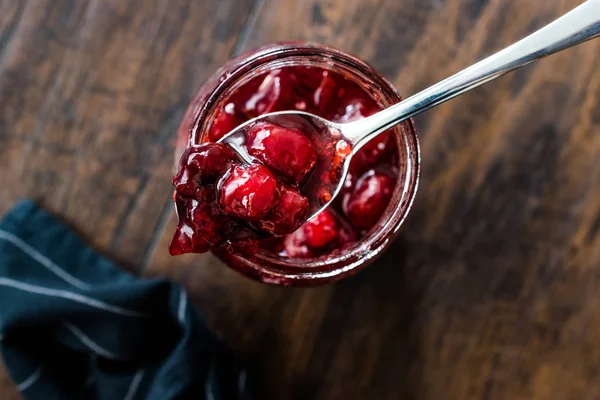 Preiselbeermarmelade im Glas mit Löffel / Preiselbeermarmelade serviert mit Brotscheiben zum Frühstück. — Stockfoto