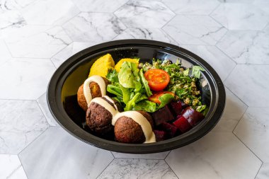 Mung Bean Salatası, Legume, Kavrulmuş Pancar ve Sarı Turnike Humus Sosu ile birlikte Siyah Plastik Tabak Kupa Paketi / Mermer Yüzey Üzerinde Konteynır.