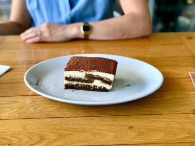 Tiramisu. Yerel restoranda geleneksel İtalyan tatlıları beyaz tabakta. Hizmet ve Yemeye Hazır.