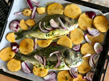 Fırın tepsisinde Pesto soslu ve fırında pişirilmiş Dorada Fish Sea Bream. Sağlıklı Organik Gıda.