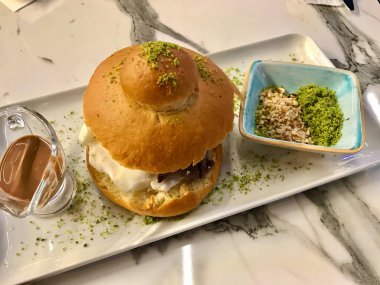 Lokantada çikolatalı sos ve fındık fıstıklı pudra ile servis edilen Brioches ekmeğinde dondurma. Yemeye hazır..