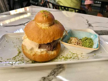 Lokantada çikolatalı sos ve fındık fıstıklı pudra ile servis edilen Brioches ekmeğinde dondurma. Yemeye hazır..