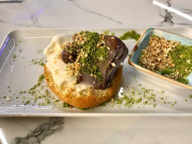 Lokantada çikolatalı sos ve fındık fıstıklı pudra ile servis edilen Brioches ekmeğinde dondurma. Yemeye hazır..