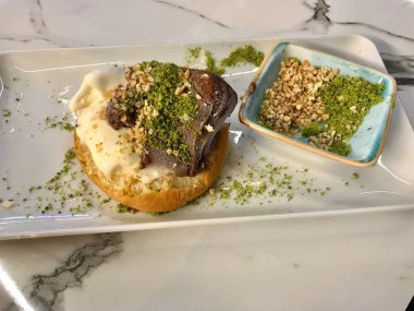Lokantada çikolatalı sos ve fındık fıstıklı pudra ile servis edilen Brioches ekmeğinde dondurma. Yemeye hazır..