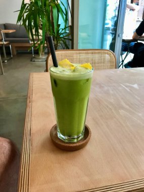 Green Detox Juice with Celery, Zucchini Courgette, Green Apple Granny Smith, Lemon Peel and Ice in Glass restoranda servis ediliyor. Sağlıklı Organik Soğuk İçecek.
