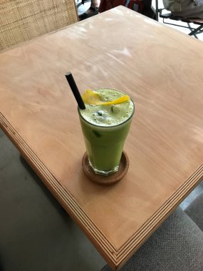 Green Detox Juice with Celery, Zucchini Courgette, Green Apple Granny Smith, Lemon Peel and Ice in Glass restoranda servis ediliyor. Sağlıklı Organik Soğuk İçecek.