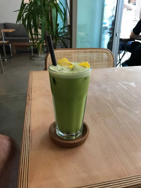 Green Detox Juice with Celery, Zucchini Courgette, Green Apple Granny Smith, Lemon Peel and Ice in Glass restoranda servis ediliyor. Sağlıklı Organik Soğuk İçecek.