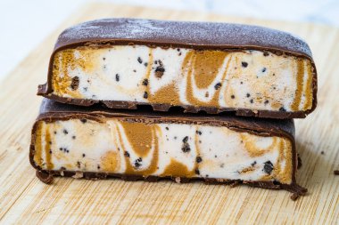 Çikolata kaplı dondurma sandviçi, tuzlu karamel ve tahtadan yapılmış vanilyalı. Yemeye hazır..