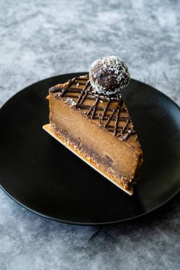 Kaju fıstıklı çiğ çikolatalı kek ve Paleo diyeti için tarih meyveli tatlandırıcı. Siyah tabakta şekersiz ve glütensiz sağlıklı organik tatlı. Hizmet ve Yemeye Hazır.