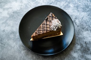 Kaju fıstıklı çiğ çikolatalı kek ve Paleo diyeti için tarih meyveli tatlandırıcı. Siyah tabakta şekersiz ve glütensiz sağlıklı organik tatlı. Hizmet ve Yemeye Hazır.