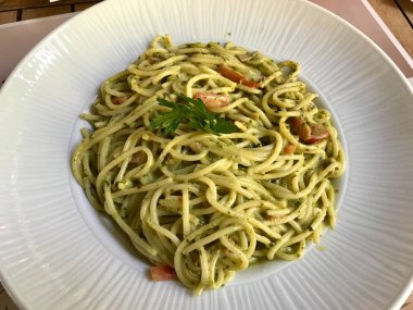 Restorandaki büyük tabakta pesto soslu yeşil spagetti. Hizmet ve Yemeye Hazır.
