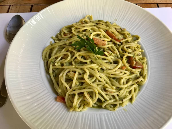 Restorandaki büyük tabakta pesto soslu yeşil spagetti. Hizmet ve Yemeye Hazır.