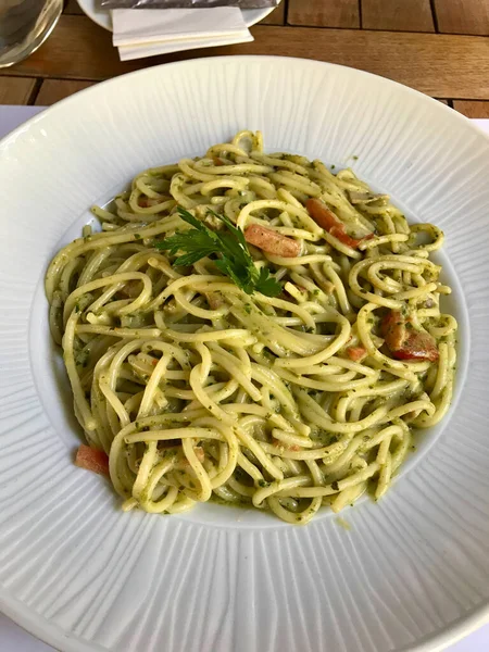 Restorandaki büyük tabakta pesto soslu yeşil spagetti. Hizmet ve Yemeye Hazır.