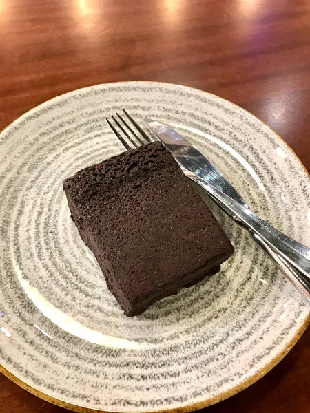 Plate Fork and Knife 'deki kafe' de servis edilen badem unuyla pişirilmiş glütensiz ve şekersiz çikolatalı unsuz kek. Yemeye hazır..