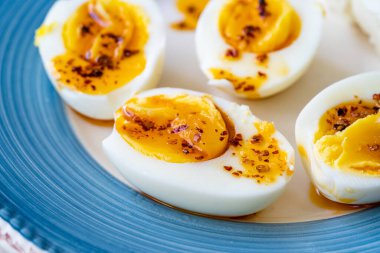 Sıcak tereyağlı haşlanmış yumurta ve acı biber sosu. Kahvaltı Tabağında Yarı Kesim Stili. Sağlıklı Organik Gıda.