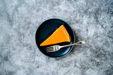 Balkabağı turtası, Şükran Günü için yapılan tart ve buğday unu siyah tabakta. Gri taş arka plan. Hizmet ve Yemeye Hazır.