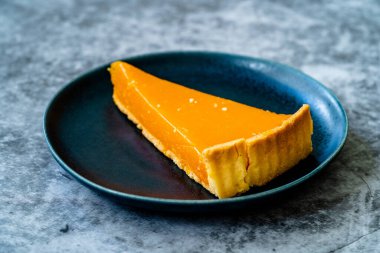 Balkabağı turtası, Şükran Günü için yapılan tart ve buğday unu siyah tabakta. Gri taş arka plan. Hizmet ve Yemeye Hazır.