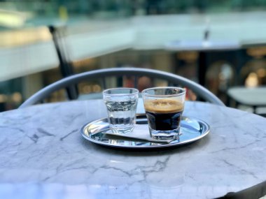Geleneksel Espresso, Mermer Masa 'daki Cafe Shop' ta suyla servis edilir. İçmeye hazır..
